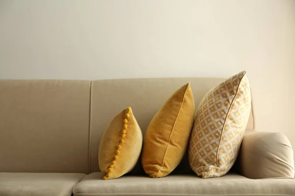 Three pillows on sofa near wall in room. Interior design
