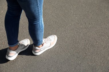 Dışarıda yürüyen bir kadın, mesaj için yer ararken yakın plan. Yol konsepti seçiliyor.