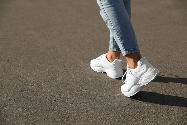 Dışarıda yürüyen bir kadın, mesaj için yer ararken yakın plan. Yol konsepti seçiliyor.