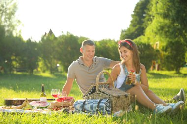 Mutlu çift güneşli bir günde parkta piknik yapıyor.