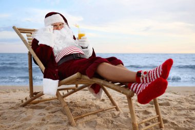 Noel Baba sahilde kokteyl içip dinleniyor. Noel tatili