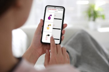 Çevrimiçi alışveriş yapan kadın akıllı telefonu içeride kullanıyor, yakın plan.