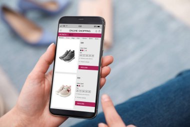 Çevrimiçi akıllı telefondan alışveriş yapan bir kadın. Kapalı alanda.