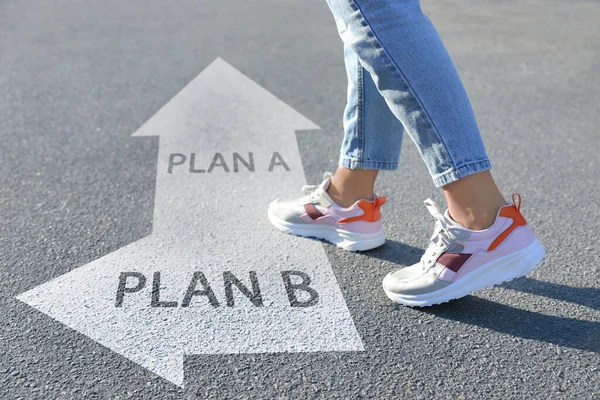 Choosing between Plan A and Plan B. Woman near pointers on road, closeup view