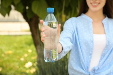 Dışarıda temiz su şişesi olan bir kadın, yakın plan.