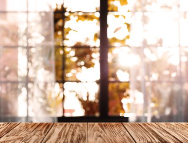Güneşli sonbahar gününde pencerenin yanındaki boş ahşap masa