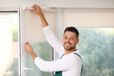 Üniformalı bir adam içeride paten penceresi kuruyor.