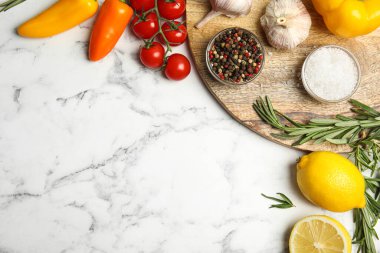 Beyaz mermer masada yemek pişirmek için malzemelerle bezenmiş düz bir kompozisyon. Metin için boşluk