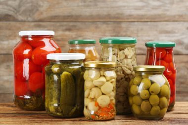 Ahşap masada kavanozlar dolusu sebze turşusu.