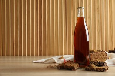 Bir şişe taze kvass, dikenler ve ahşap masada ekmek. Metin için boşluk