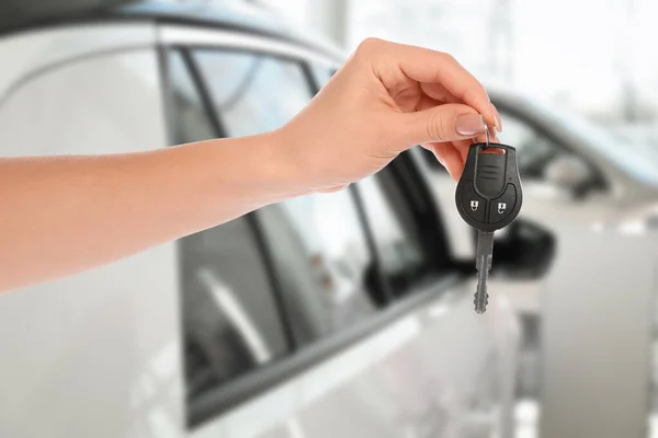 車の購入 ぼやけた自動車に対してキーを保持する女性 クローズアップ — ストック写真