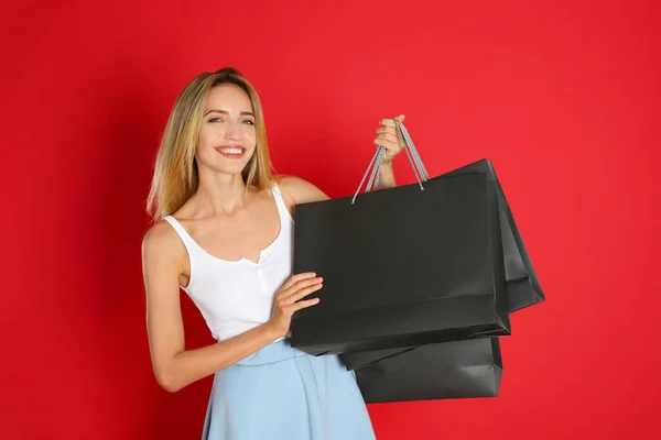 Mujer Joven Feliz Con Bolsas Compras Sobre Fondo Rojo Viernes — Foto de Stock