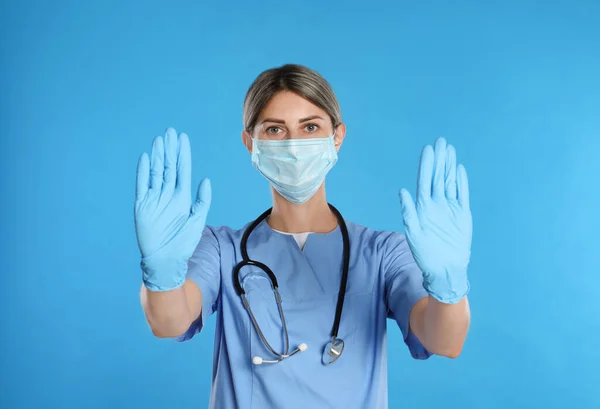 Dokter Beschermend Masker Toont Stop Gebaar Lichtblauwe Achtergrond Voorkomen Van — Stockfoto