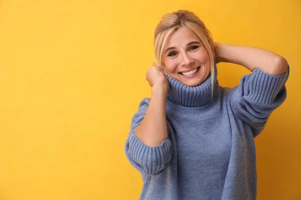 Happy woman in stylish sweater on yellow background. Space for text