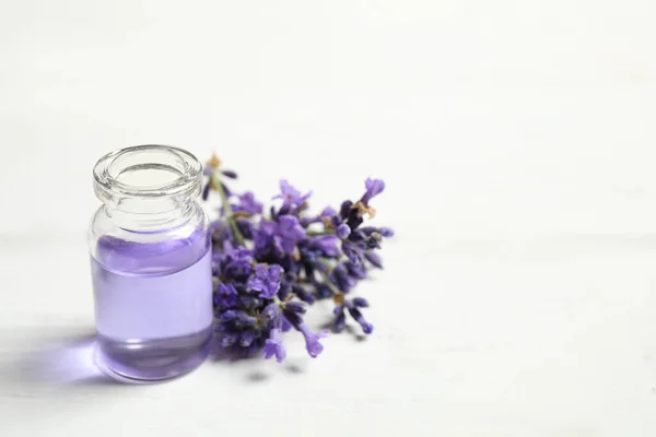 Flaska Med Eterisk Olja Och Lavendel Blommor Vitt Träbord Plats — Stockfoto