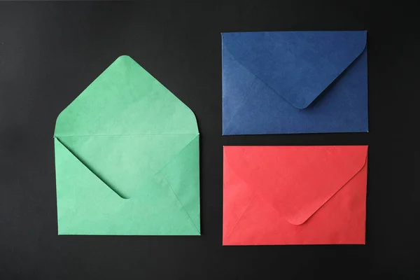 Siyah Zemin Üzerinde Renkli Kağıt Zarflar Düz Yatıyordu — Stok fotoğraf