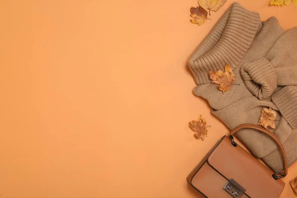 Platt Låg Komposition Med Tröja Och Torra Blad Orange Bakgrund — Stockfoto