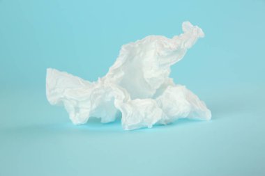 Açık mavi arkaplanda kullanılan kağıt mendil, yakın plan