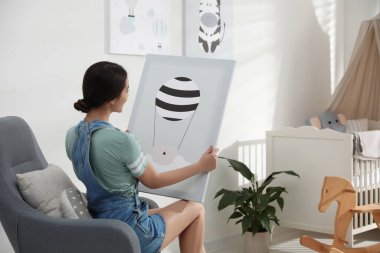 İçerde oturan resimli bir dekoratör. Çocuk odası iç tasarımı.