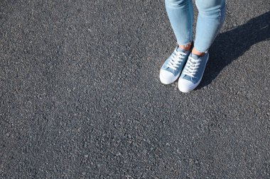 Dışarıda duran bir kadın, mesaj için yere yakın duruyor. Yol konsepti seçiliyor.