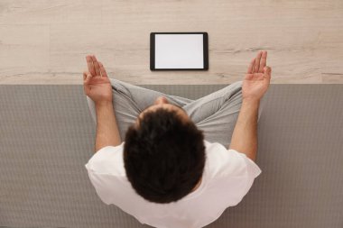 Coronavirus salgını sırasında evde online ders izlerken yoga yapan bir adam. Sosyal uzaklık