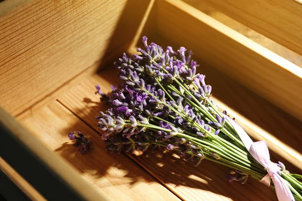 Beautiful fresh lavender bouquet in wooden crate, closeup