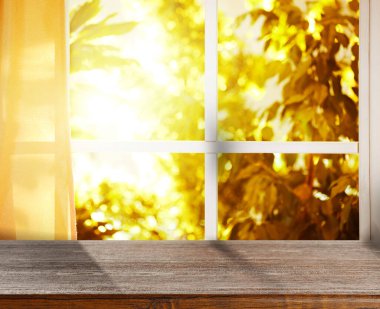 Güneşli sonbahar gününde pencerenin yanındaki boş ahşap masa