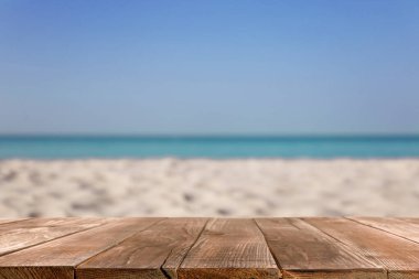 Okyanusun yakınındaki kumlu sahilde ahşap yüzey