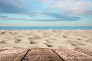 Okyanusun yakınındaki kumlu sahilde ahşap yüzey
