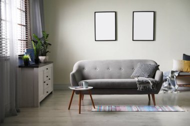 Duvarında boş posterler olan şık bir oda. Tasarım için model 