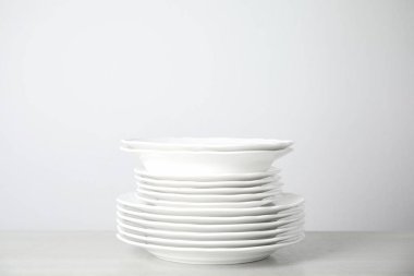 Masada beyaz arka planda bir yığın temiz tabak var. Metin için boşluk