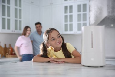 Modern hava nemlendiricisi olan bir aile mutfakta.
