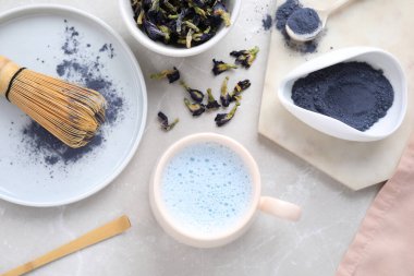 Açık gri mermer masa üzerinde mavi kibrit latte ile düz konum