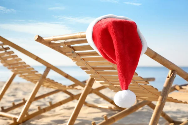 Leżak Kapeluszem Mikołaja Plaży Zbliżenie Święta Bożego Narodzenia — Zdjęcie stockowe