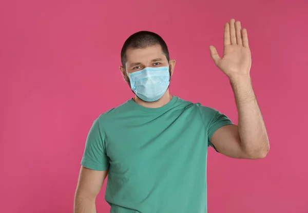Mannen Skyddande Mask Visar Hallogest Rosa Bakgrund Att Hålla Socialt — Stockfoto
