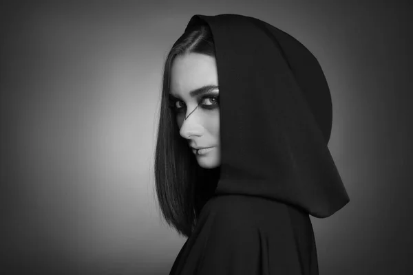 暗い背景にフードを持つマントルの神秘的な魔女 白黒効果 — ストック写真