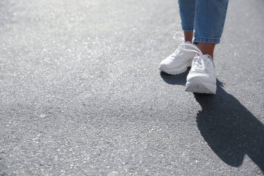 Dışarıda yürüyen bir kadın, mesaj için yer ararken yakın plan. Yol konsepti seçiliyor.