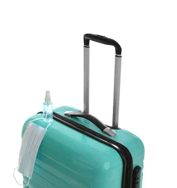 スタイリッシュなターコイズスーツケース 防腐スプレー 白い背景の保護マスク コロナウイルスのパンデミックの間の旅行 — ストック写真