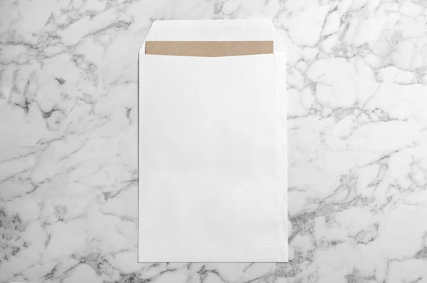 大理石の背景に白い紙の封筒 トップビュー — ストック写真