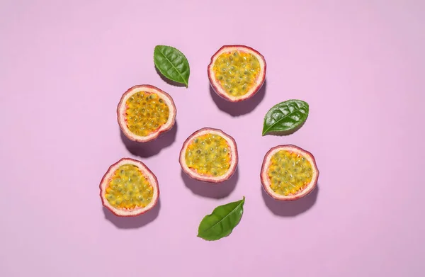 Halves Passion Fruits Maracuyas Green Leaves Pink Background Flat Lay — Stock Photo, Image