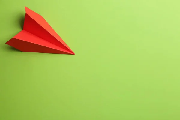 緑の背景に赤い紙飛行機 トップビュー テキストのスペース — ストック写真