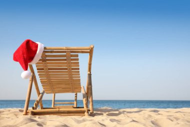 Plajda Noel Baba 'nın şapkasıyla güneşlik, mesaj için yer. Noel tatili