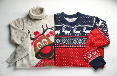 Beyaz ahşap masada sıcak Noel kazakları, üst manzara.