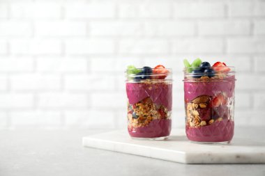 Acai smoothie, granola ve mermer masada böğürtlenli tatlı. Metin için boşluk