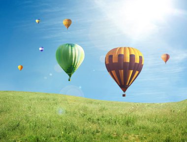 Hayal dünyası. Mavi gökyüzünde yeşil çayır üzerinde sıcak hava balonları