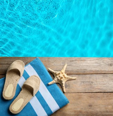 Plaj aksesuarları yüzme havuzunun yanındaki ahşap güvertede, düz yerde. Metin için boşluk 