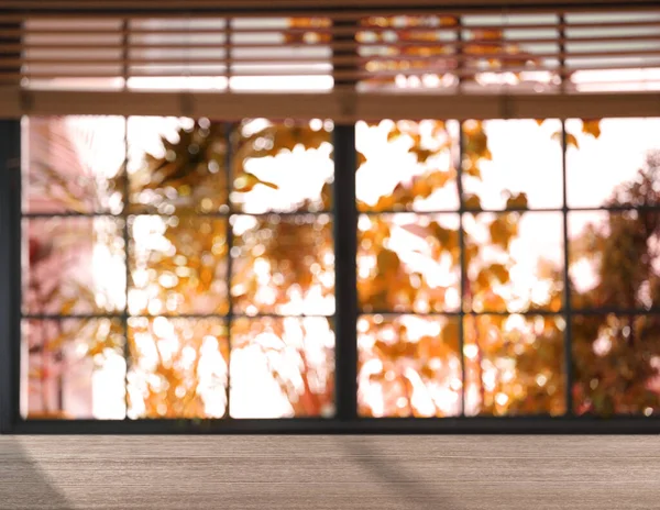 Güneşli sonbahar gününde pencerenin yanındaki boş ahşap masa