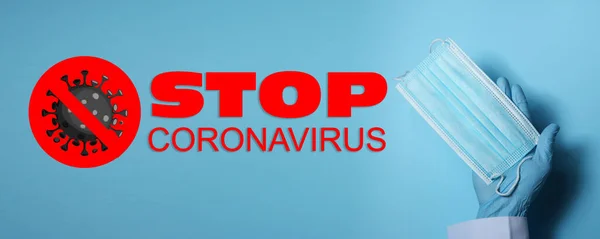 Lekarz Trzymający Maskę Medyczną Pobliżu Tekstu Stop Coronavirus Jasnoniebieskim Tle — Zdjęcie stockowe
