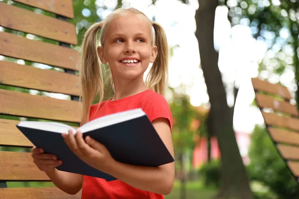 幸せな女の子読書本で公園 — ストック写真