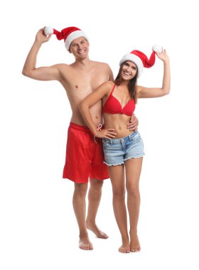 Beyaz arka planda Noel Baba şapkalı mutlu çift. Noel tatili